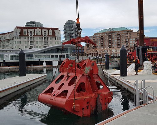 Red dredging bucket at a marina under construction