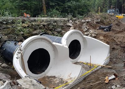 Large culvert sections ready for installation at a stream crossing