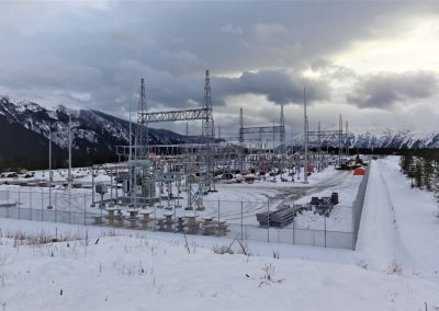 BC Hydro substation in snow below the mountains